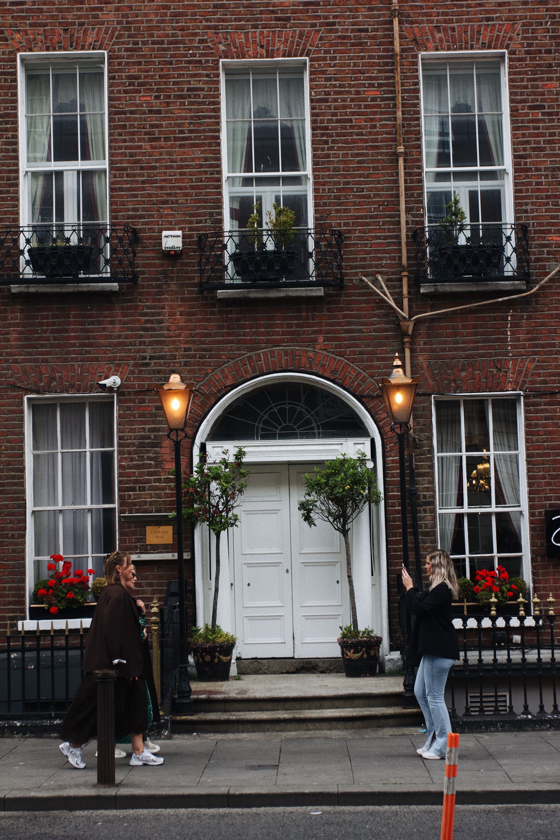 A Dublin Georgian house: red brick, white fanlight, and a door onto the street.